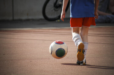 Junge kickt Fußball auf Hartplatz, Teilansicht - LVF000996