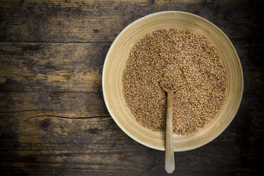 Bowl of spelt grains on dark wooden table, elevated view - LVF000986