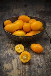 Bowl of kumquats on wooden table - LVF000983