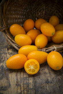 Korb mit Kumquats auf Holztisch - LVF000981