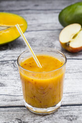 Glas Mango-Apfel-Smoothie auf grauem Holztisch - LVF000978