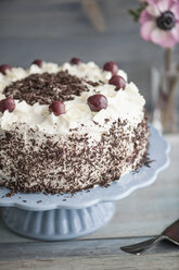 Schwarzwälder Kirschtorte auf blauem Tortenständer vor grauem Hintergrund - IPF000098