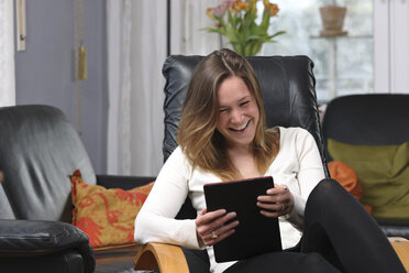 Young woman having fun with tablet computer at home - LAF000719