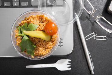 Arbeitsplatz mit Gemüse-Couscous auf Laptop - CSTF000220