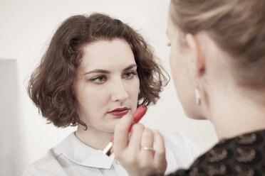 Zwei junge Frauen tragen Make-up im Retrostil auf - DISF000724