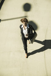 Business woman hurrying on parking level, elevated view - UUF000118