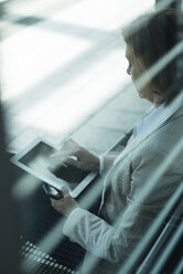 Geschäftsfrau mit Tablet-Computer beim Warten auf dem Bahnsteig - UUF000120