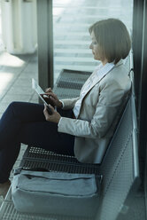 Geschäftsfrau mit Tablet-Computer beim Warten auf dem Bahnsteig - UUF000121