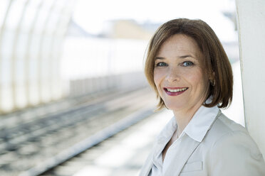 Porträt einer Geschäftsfrau, die auf dem Bahnsteig wartet - UUF000123