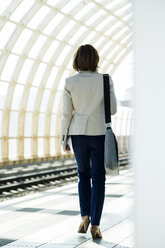 Geschäftsfrau wartet auf dem Bahnsteig - UUF000126