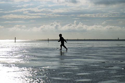 Germany, Schleswig-Holstein, Sankt Peter-Ording, North Sea, boy running at beach stock photo