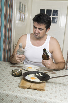 Porträt eines Mannes mit schlechter Angewohnheit am Frühstückstisch sitzend - CSBF000019