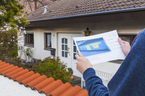 Deutschland, Geislingen, Person mit Gebäudethermografie - WDF002453