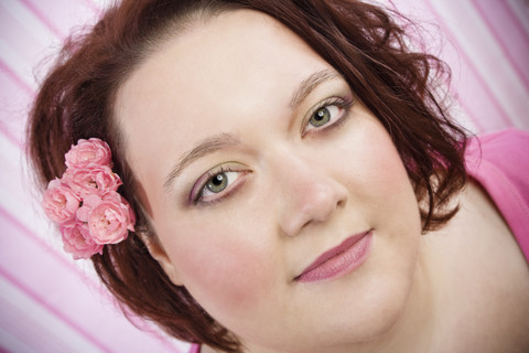 Porträt einer Frau mit rosa Blumen, lizenzfreies Stockfoto