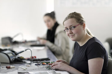 Zwei junge Frauen arbeiten an einem optischen Sensor in einer Elektronikwerkstatt - SGF000537