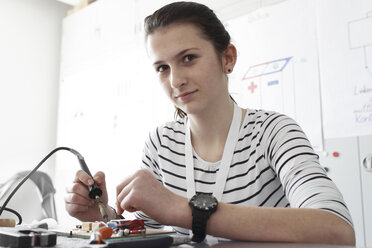 Junge Frau bei der Arbeit an einem optischen Sensor in einer Elektronikwerkstatt - SGF000540