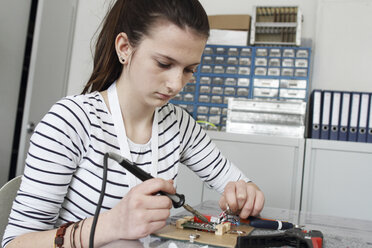 Junge Frau bei der Arbeit an einem optischen Sensor in einer Elektronikwerkstatt - SGF000541