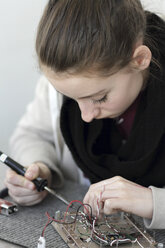 Junge Frau bei der Arbeit an einem optischen Sensor in einer Elektronikwerkstatt - SGF000546