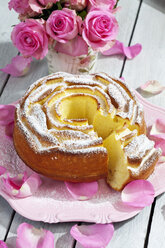 Birthday cake on plate, pink roses and petals on wooden table - CSF021209