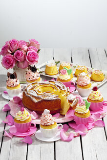 Geburtstagskuchen, Cupcakes, Muffins und Blumenvase mit rosa Rosen auf Holztisch - CSF021211