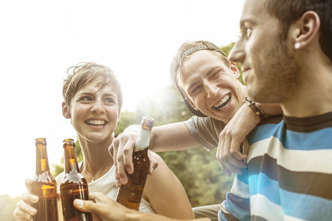 Drei Freunde entspannen sich mit Bierflaschen, lizenzfreies Stockfoto