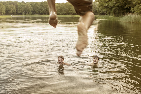 Junger Mann springt in Baggersee, lizenzfreies Stockfoto