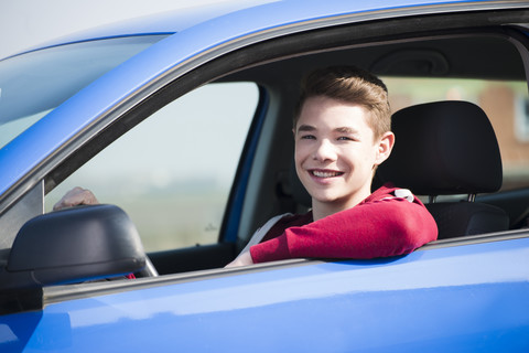 Teenager sitting in car, partial view stock photo