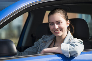Lächelndes jugendliches Mädchen im Auto sitzend, Teilansicht - UUF000177