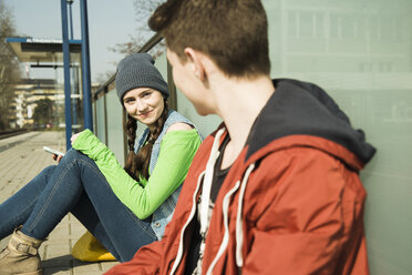 Teenager und junges Mädchen warten auf dem Bahnsteig - UUF000197