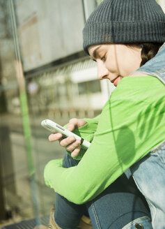 Porträt eines lächelnden Teenagers mit Smartphone - UUF000201