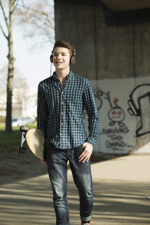 Jugendlicher mit Skateboard hört Musik - UUF000168