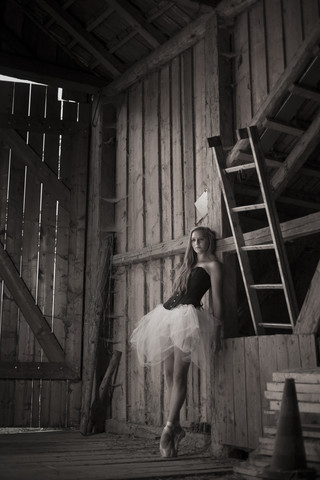 Young woman with tutu standing in barn stock photo