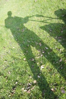 Deutschland, Petershagen, Schatten eines Mannes beim Rasenmähen - HAWF000084