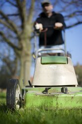 Germany, Petershagen, Man mowing lawn - HAWF000085