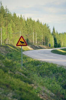 Schweden, Jokkmokk, Elch überquert Straßenschild an Landstraße - BR000412
