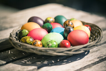 Germany, Colorful Easter eggs on wooden table - SARF000457