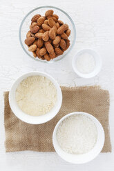 Mandeln, Kokosflocken und Backpulver in Schüsseln für glutenfreie Karotten-Kokos-Bananen-Cupcakes - EVGF000515