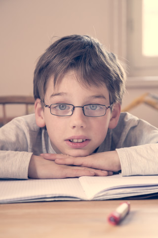 Porträt eines kleinen Jungen bei den Hausaufgaben, lizenzfreies Stockfoto