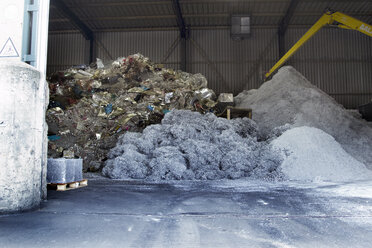 Stapel verschiedener Materialien in einer Industriehalle auf einem Recyclinghof - SGF000560