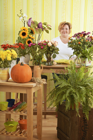 Mittlere erwachsene Frau im Blumenladen, lizenzfreies Stockfoto