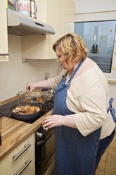 Germany, Mid-adult woman in kitchen preparing food - ECF000577