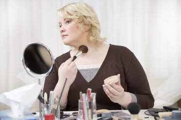 Blond woman applying make up - ECF000542