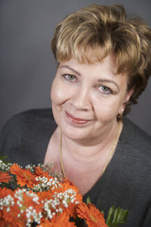 Porträt einer glücklichen Frau mit Blumenstrauß - ECF000508