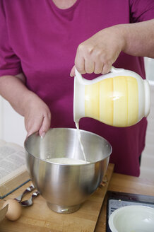 Frau bereitet Teig in ihrer Küche vor, Teilansicht - ECF000505