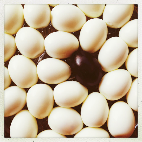 Viele geschälte Eier, gekochte Eier, ein schwarzes Ei, lizenzfreies Stockfoto