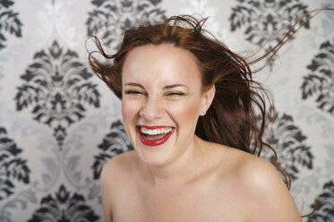 Portrait of laughing young woman in front of checkered wallpaper - ECF000518