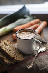 Hausgemachte Hühnerbrühe in Tasse mit Brotscheiben und Zutaten - SBDF000782