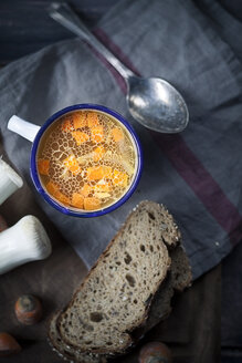 Hausgemachte Hühnerbrühe in Tasse mit Brotscheiben und Zutaten - SBDF000784