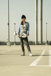 Junge Frau mit Skateboard auf Parkdeck - UUF000220