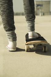 Beine einer jungen Frau mit Skateboard auf einem Parkdeck - UUF000221